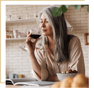Older woman drinking wine alone